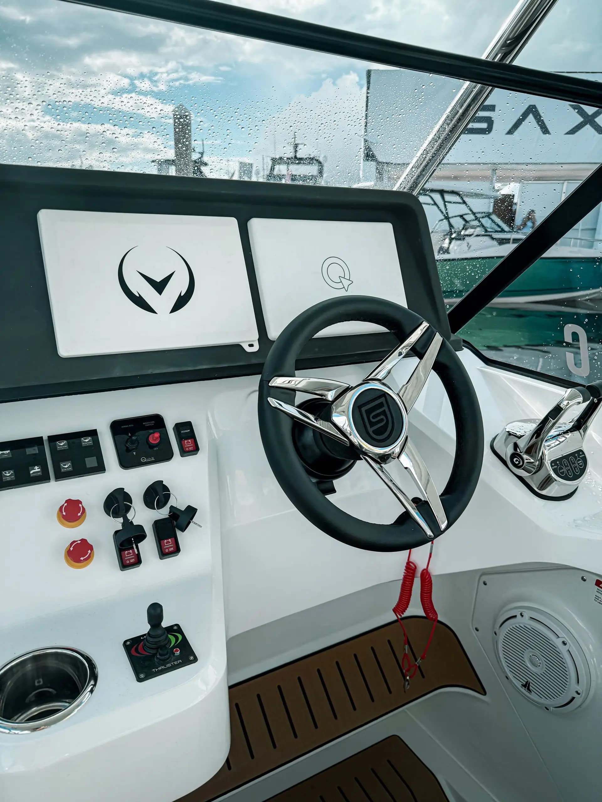 Sterk 31E helm station with dual displays, steering wheel, controls, cup holder, and teak-style flooring.