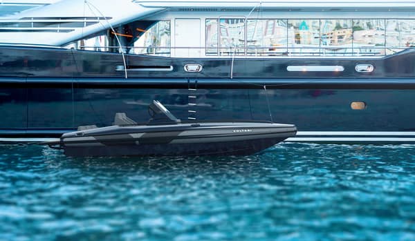 Voltari 260 T/T tender floating alongside a larger yacht, viewed from water level.