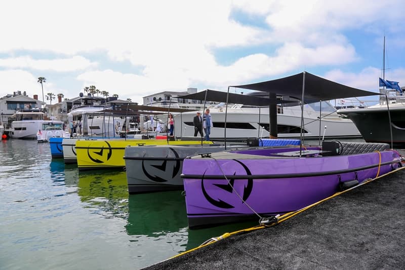 Vision Marine Volt 180 boats in colorful hulls moored at a marina, viewed from the dock.