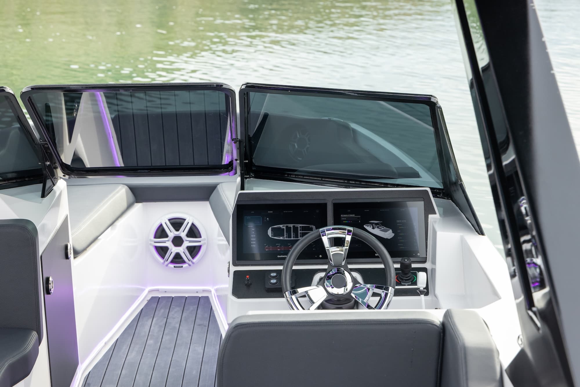 Voltaic AEW24 electric boat helm and cockpit, with steering wheel, dashboard display, windshield, seating, and speaker visible.
