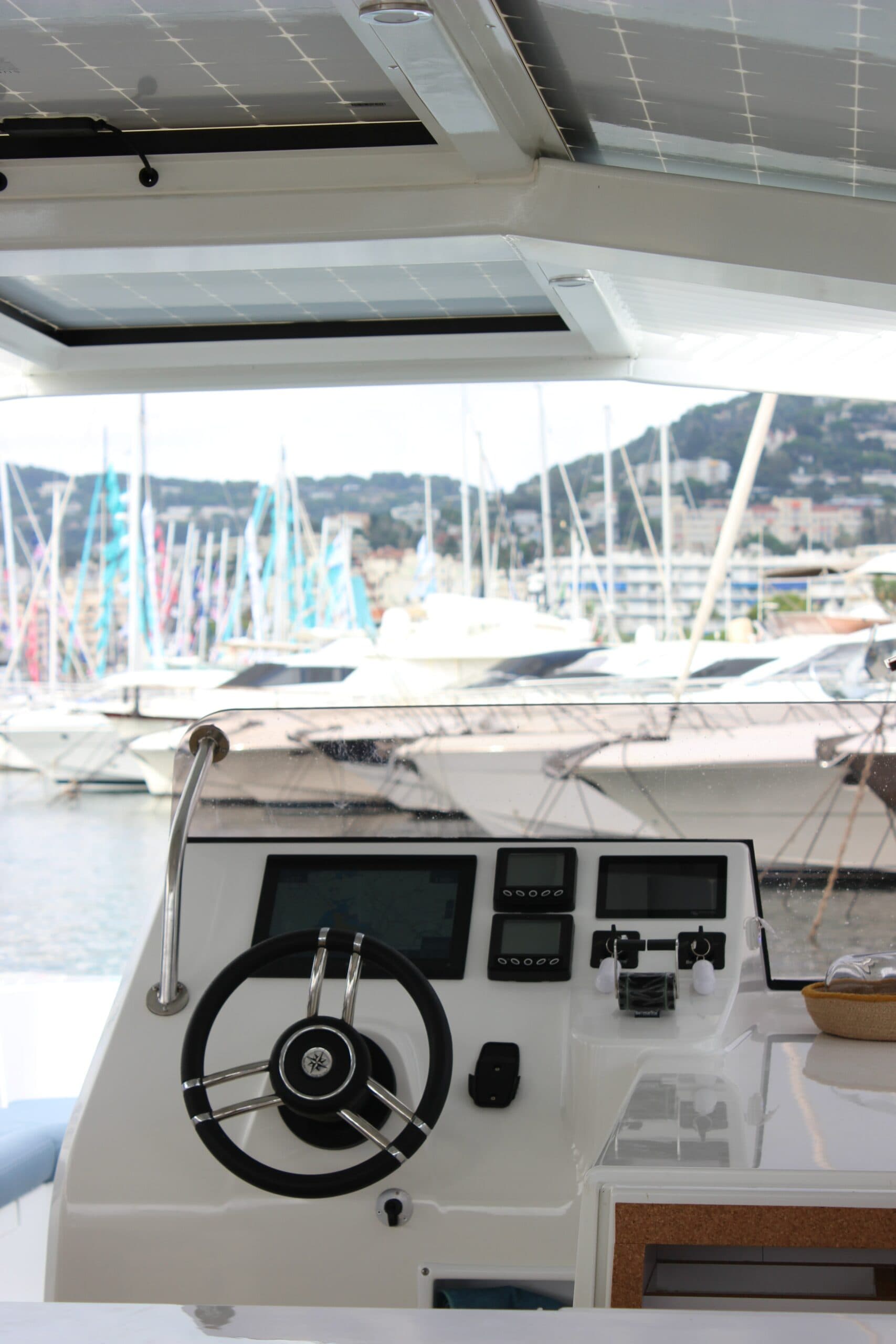 Millikan M10 helm with steering wheel, digital displays, controls, and marina visible through the windshield.