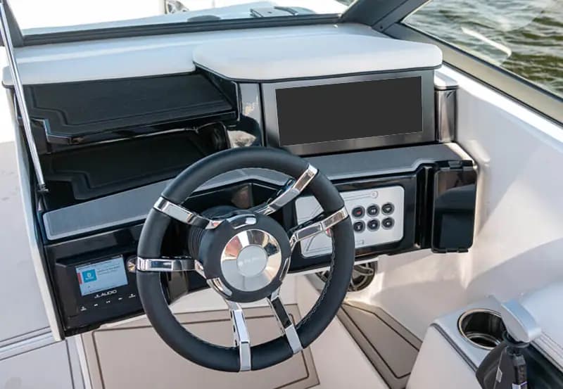 Helm of a Vision Marine SPECTR electric boat with steering wheel, dashboard display, controls, bluetooth display and cup holder.
