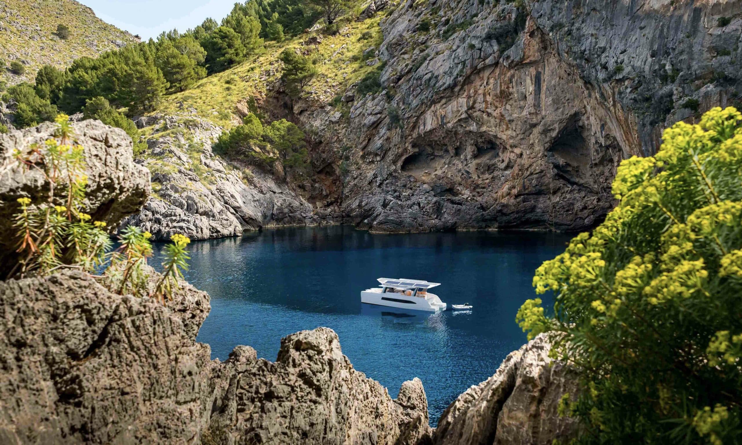 Millikan M10 boat viewed from above in a rocky coastal cove surrounded by cliffs and vegetation