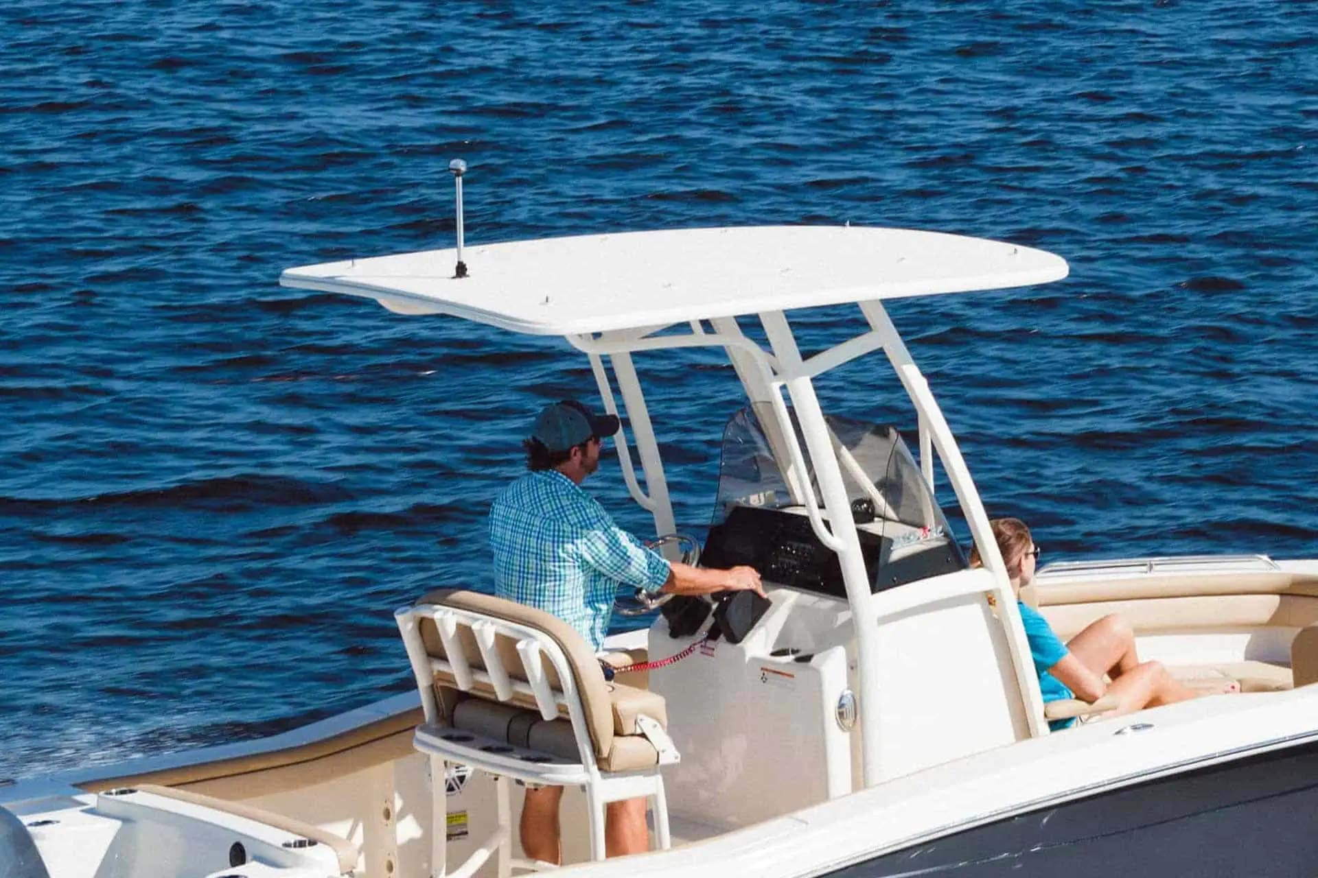 electric Scout 215 XSF center-console boat with white T-top cruising on blue water.