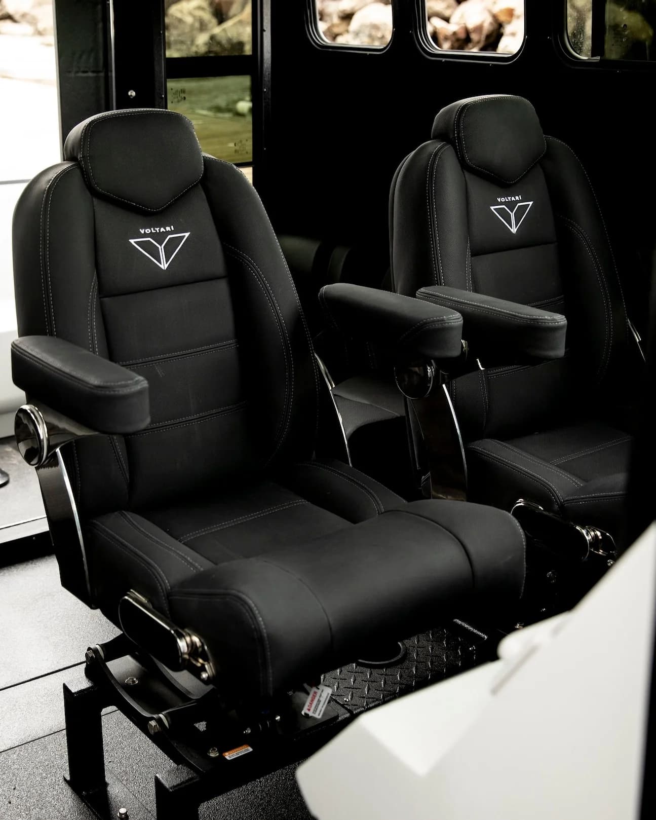 Two black suspension seats with armrests in the boat’s cockpit, viewed from the side (2026 Voltari Patrol 26).
