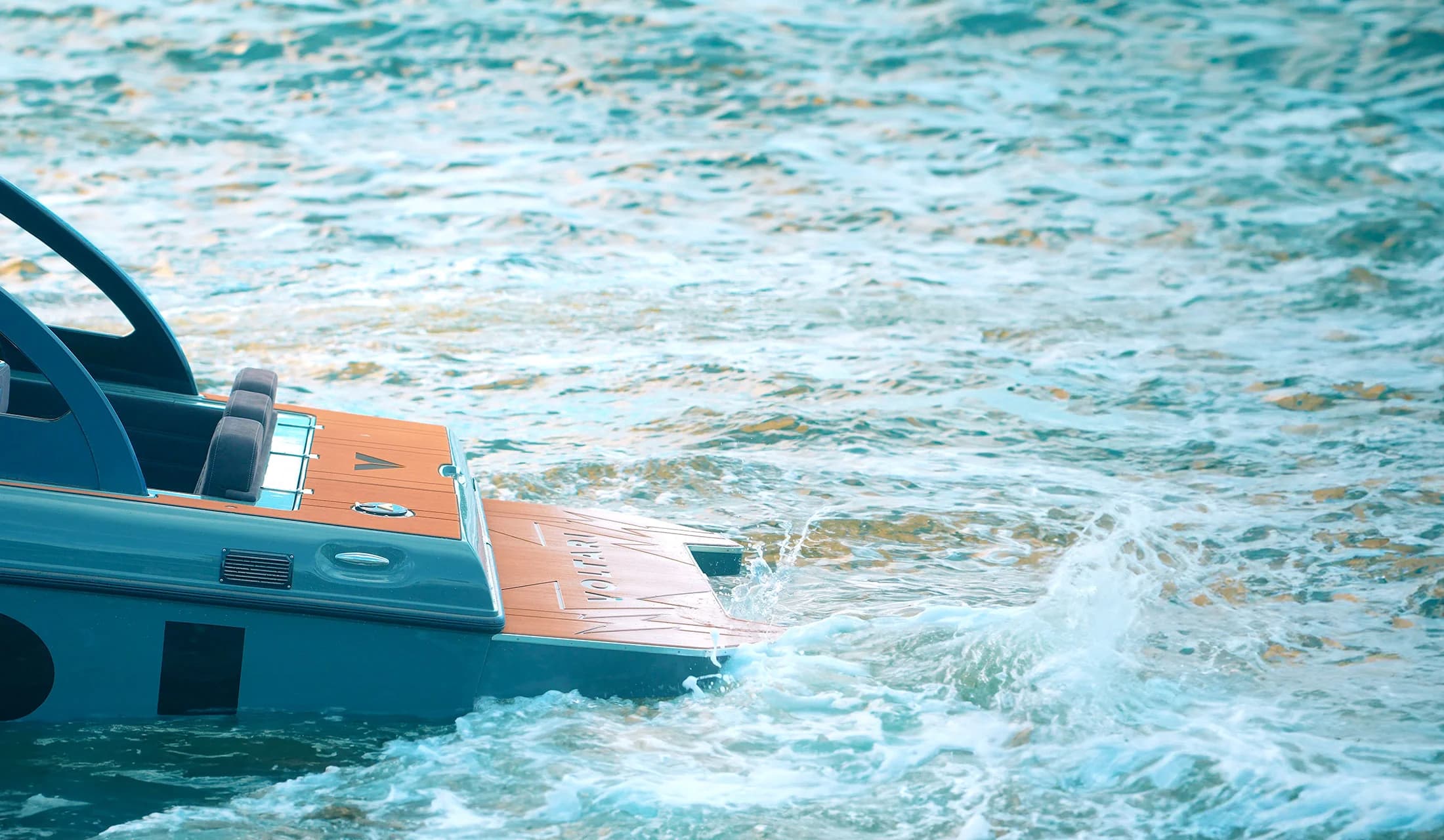 Side view of the Voltari 260E’s stern and rear deck moving through choppy water