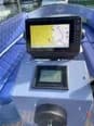 Vision Marina Fantail 217 Boat helm console with a GPS chartplotter, digital display, steering wheel, and blue upholstered seating.