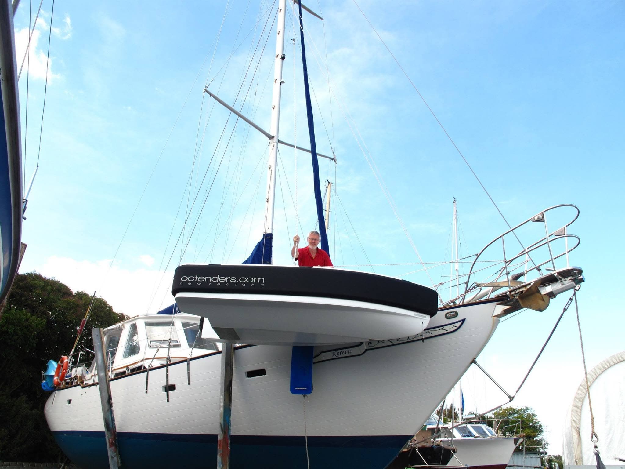 2026 Offshore Cruising Tenders OC350 viewed from the bow, with a dark hull stripe, raised anchor hardware, and a blue fender.
