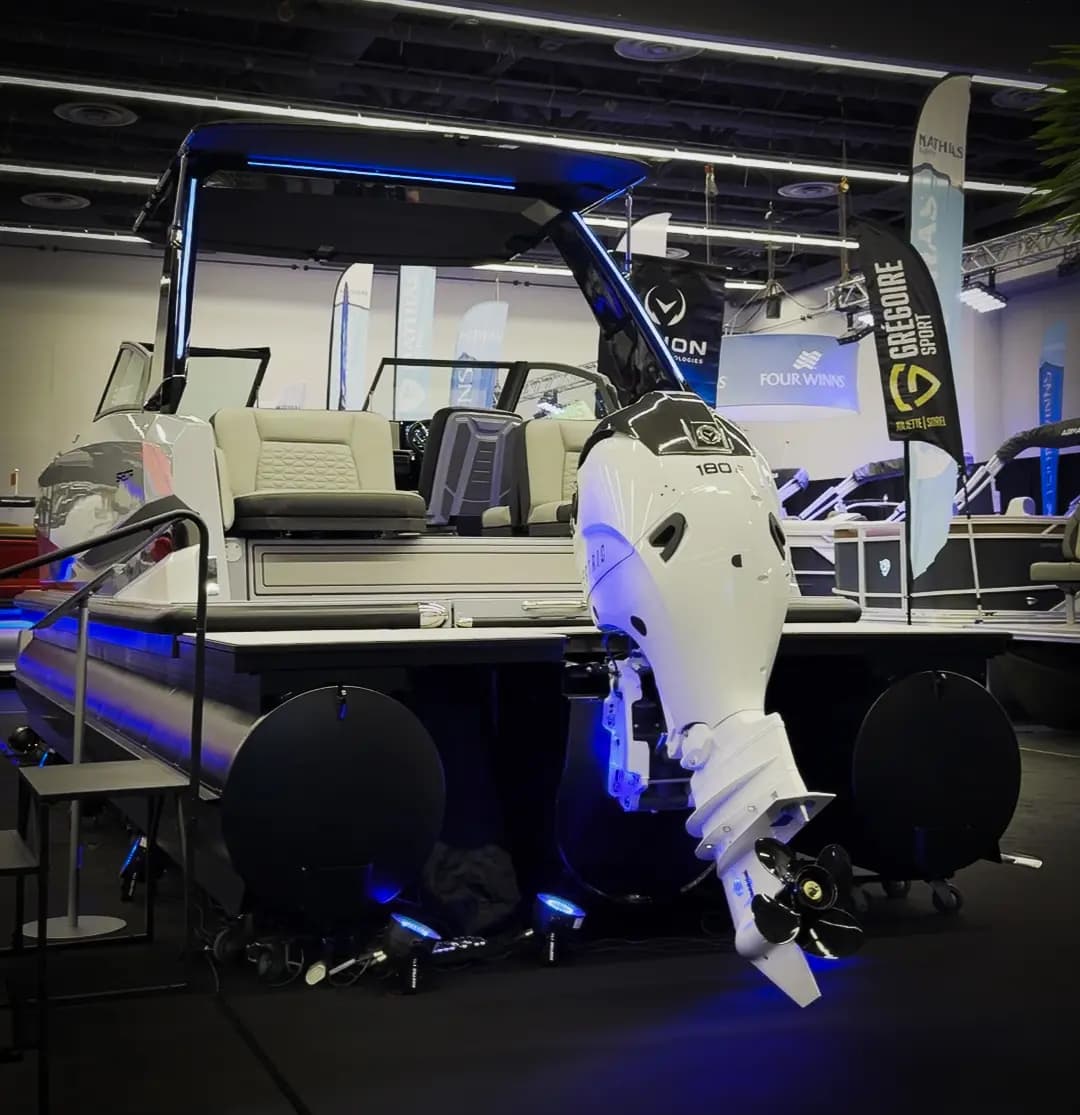 Rear view of a pontoon boat (2026 Vision Marine SPECTR) with a white outboard motor, showing the stern, cockpit seating, swim platform, and propeller.
