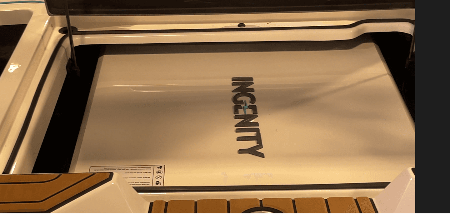 Close-up of the Ingenity-branded engine compartment cover, viewed from above at the stern.