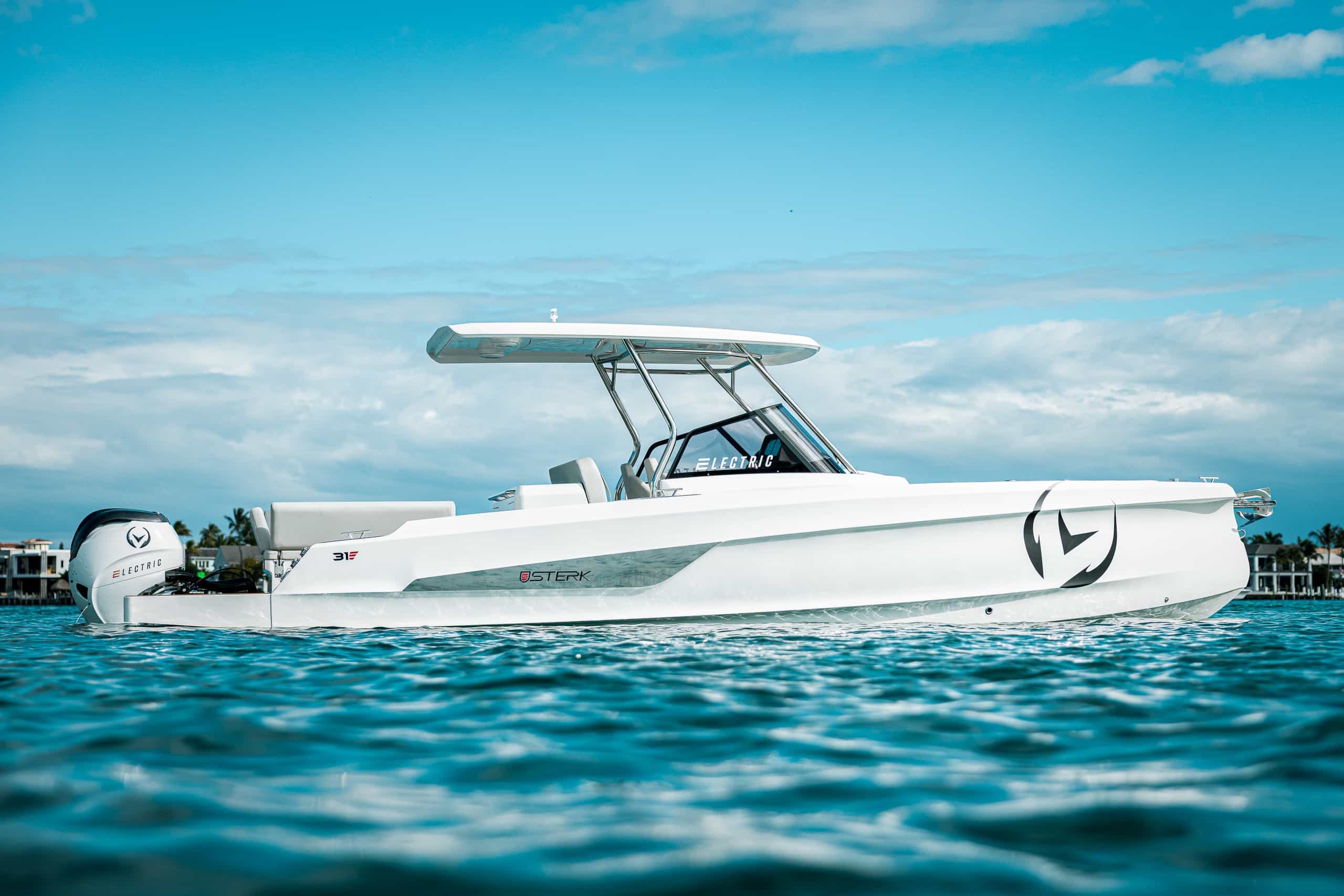 Sterk 31E viewed from the side at water level, showing the full boat with center console, canopy, and stern motor.