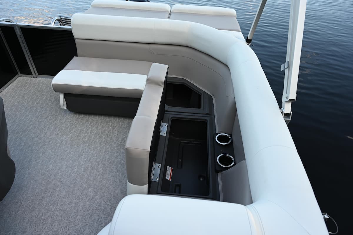View from above of a pontoon boat’s (2026 Princecraft Vectra 19 L) aft seating area, showing cushioned benches, cupholders, storage, and the swim ladder at right.