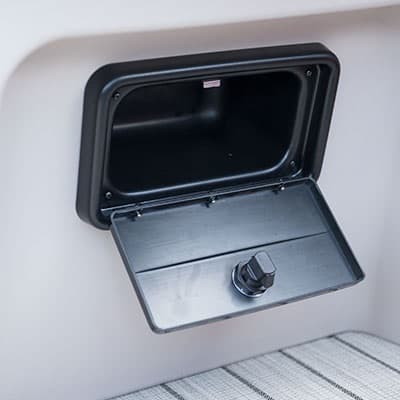 Open storage compartment with a fold-down door and latch on the boat’s (2026 Princecraft Vectra 19 L) interior side panel.