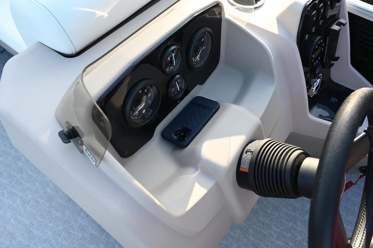 Close view of the helm console, showing gauges, steering wheel, throttle control, and cup holder from above (2026 Princecraft Vectra 19 L).
