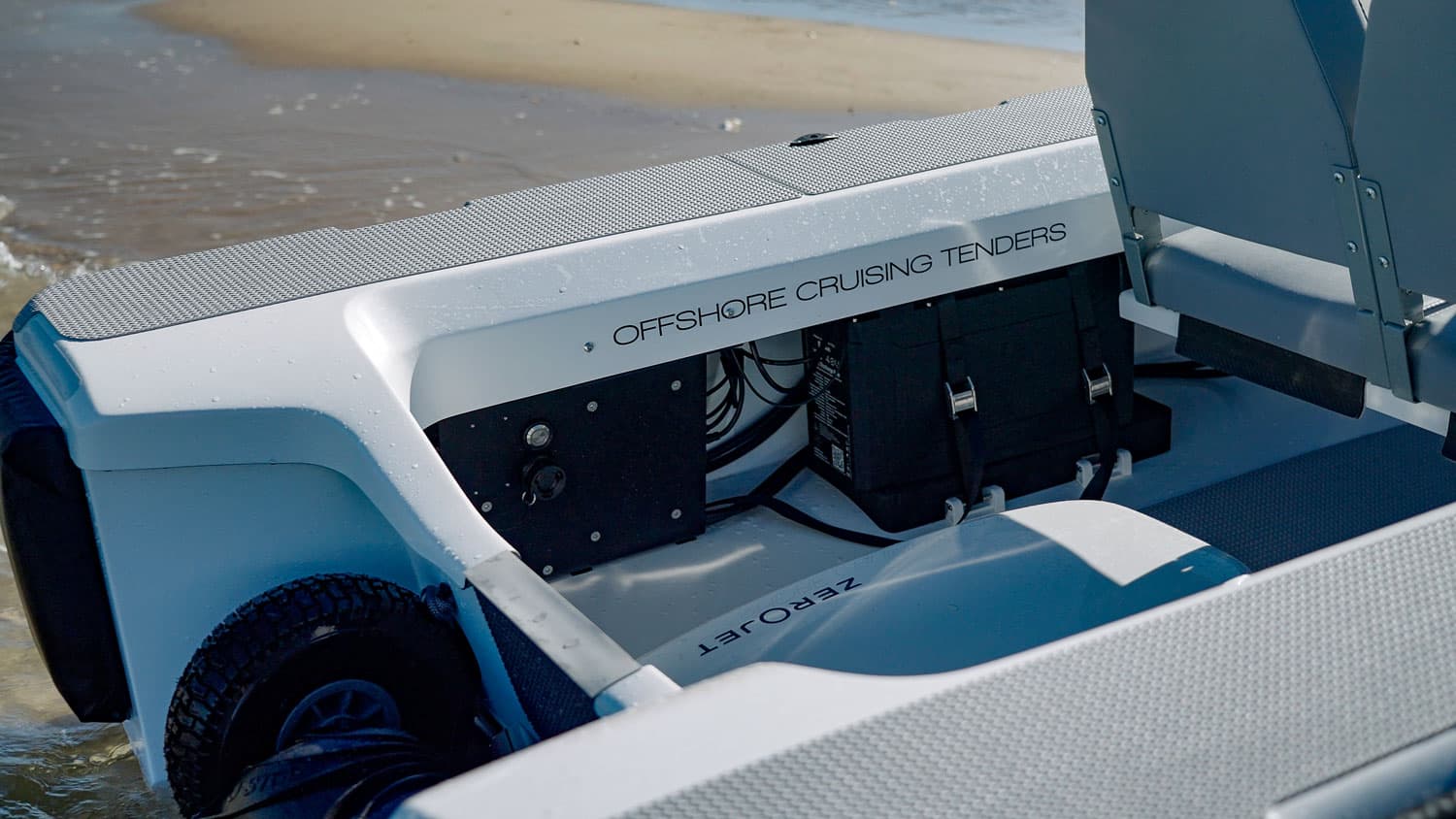 Offshore Cruising Tenders OC330 stern detail with visible wheel, storage compartments, wiring, and rear platform, viewed from inside the boat.