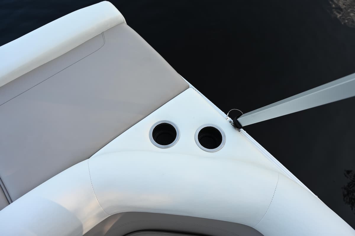 Close-up from above of a boat’s (2026 Princecraft Vectra 19 L) white upholstered bow seating and two recessed cup holders beside the gunwale.