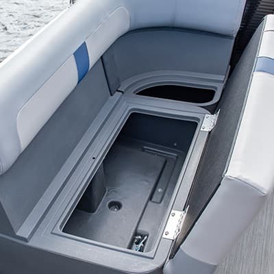 Close-up from above of the boat’s (2026 Princecraft Jazz 17) cockpit storage compartment with open rectangular bins between cushioned side seats.