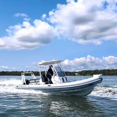 Highfield Sport 660 cruising on open water, shown in profile from the side with its center console and canopy visible