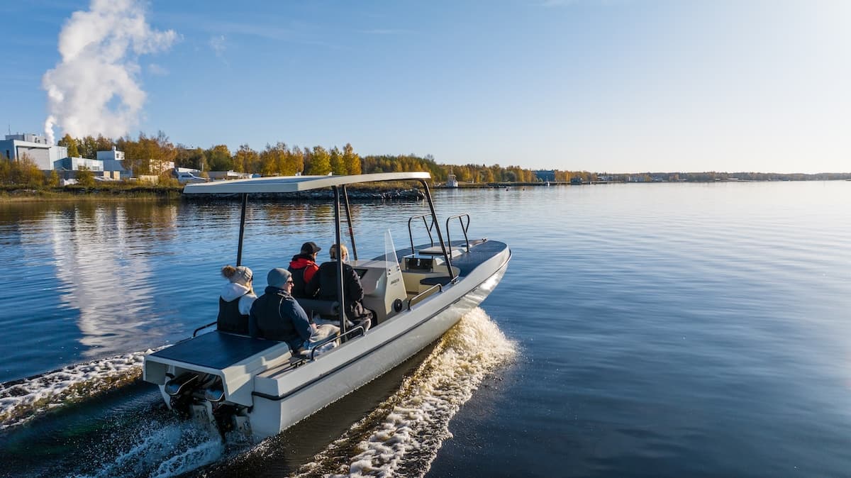 Elvene Amber boat cruising on calm water, viewed from behind at a slight angle, with several passengers aboard