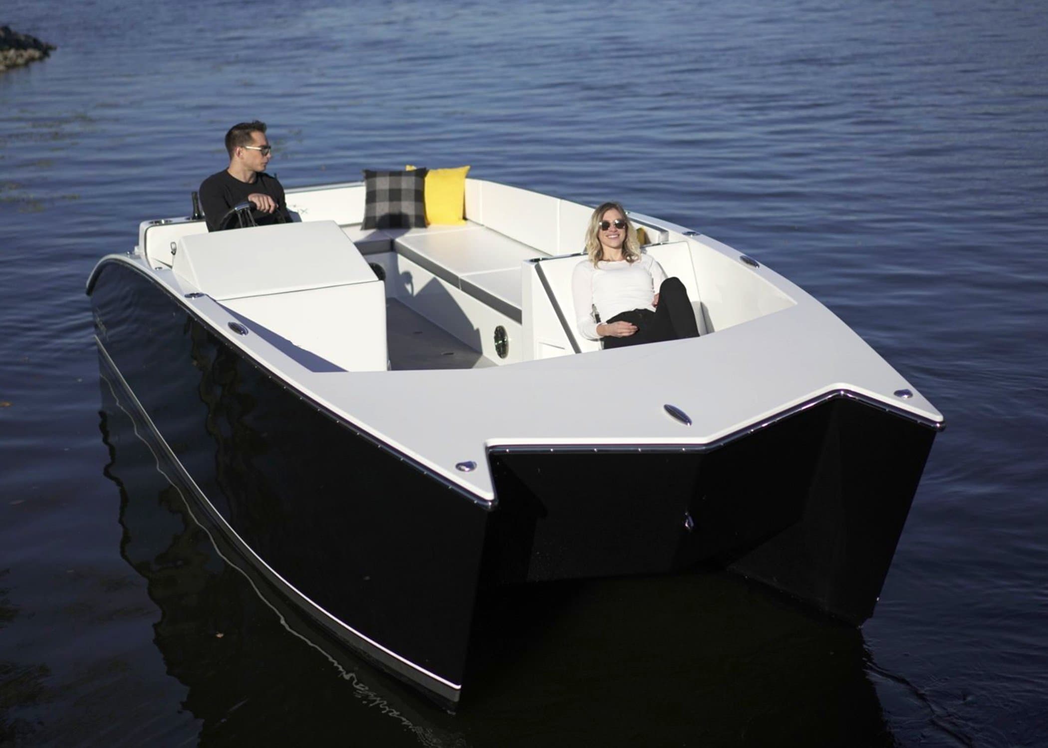 Flux Marine GFX Stealth viewed from above the bow, showing the black-and-white hull and open cockpit with two seated people.