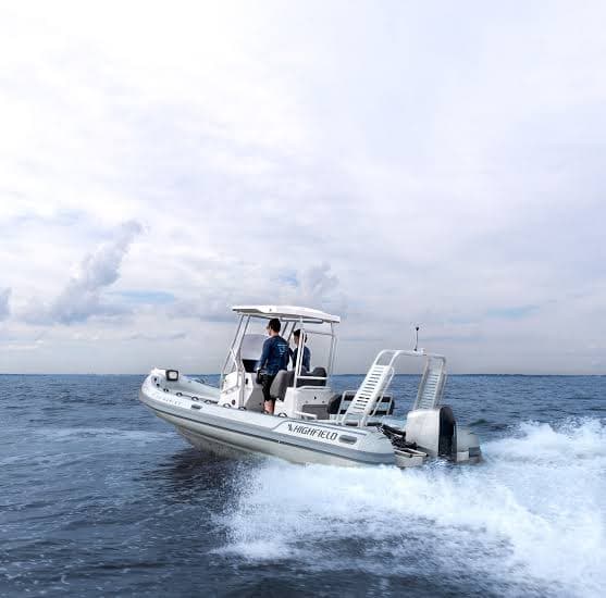 Highfield Sport 660 underway on open water, viewed from the rear starboard side with its outboard motor visible