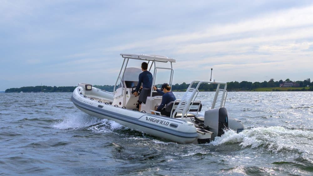 Highfield Sport 660 underway on a lake, viewed from the starboard side with two people aboard and an outboard motor visible