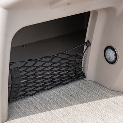 Under-seat storage compartment with elastic cargo net and round light, viewed from inside the boat (2026 Princecraft Jazz 17)