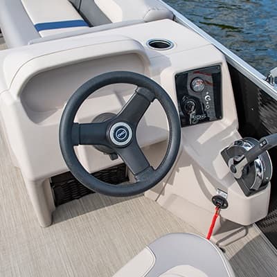 Close view of the Princecraft Jazz 17 helm, showing the steering wheel, dashboard controls, throttle, cup holder, and captain’s seat.