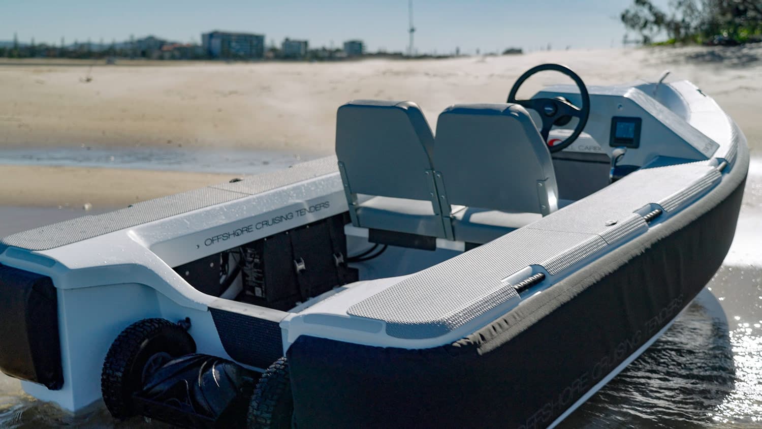 Offshore Cruising Tenders OC330 viewed from the stern, showing the cockpit, twin seats, helm, and outboard motor.