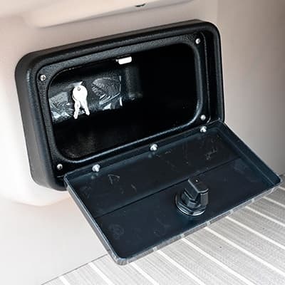 Open storage compartment with hinged lid and latch on the boat’s (2026 Princecraft Vectra 19 L) interior side panel, viewed close up.