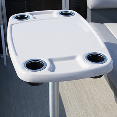 White 2026 Princecraft Jazz 19 4s table with four built-in cup holders, viewed from above beside a cushioned seat.