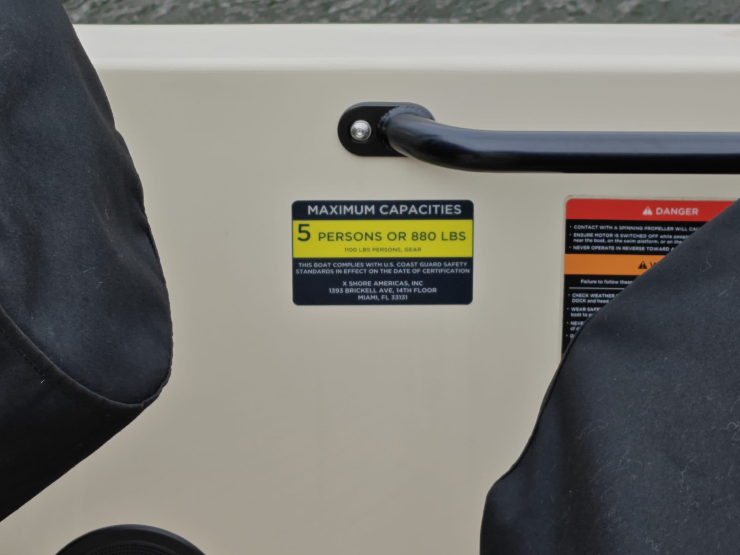 2024 Vision Marine Fantail 217
Boat interior with grab handle, maximum capacity label, and safety warning label visible on the side panel.