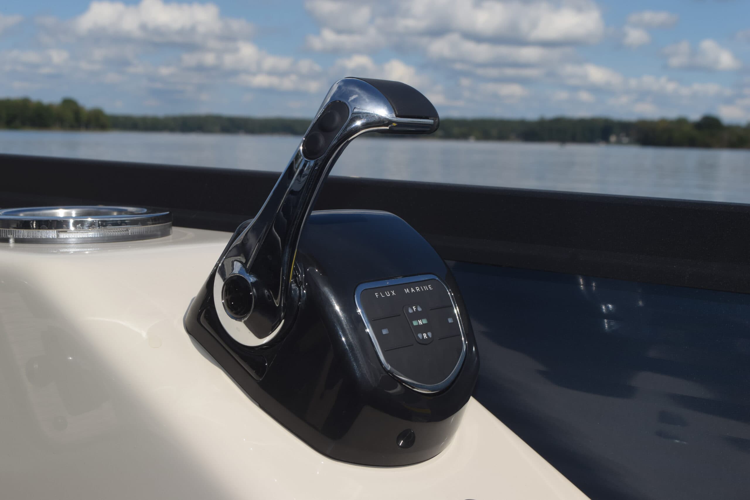 Flagship Discover throttle control mounted on the boat console, viewed close-up from the side with a lake in the background