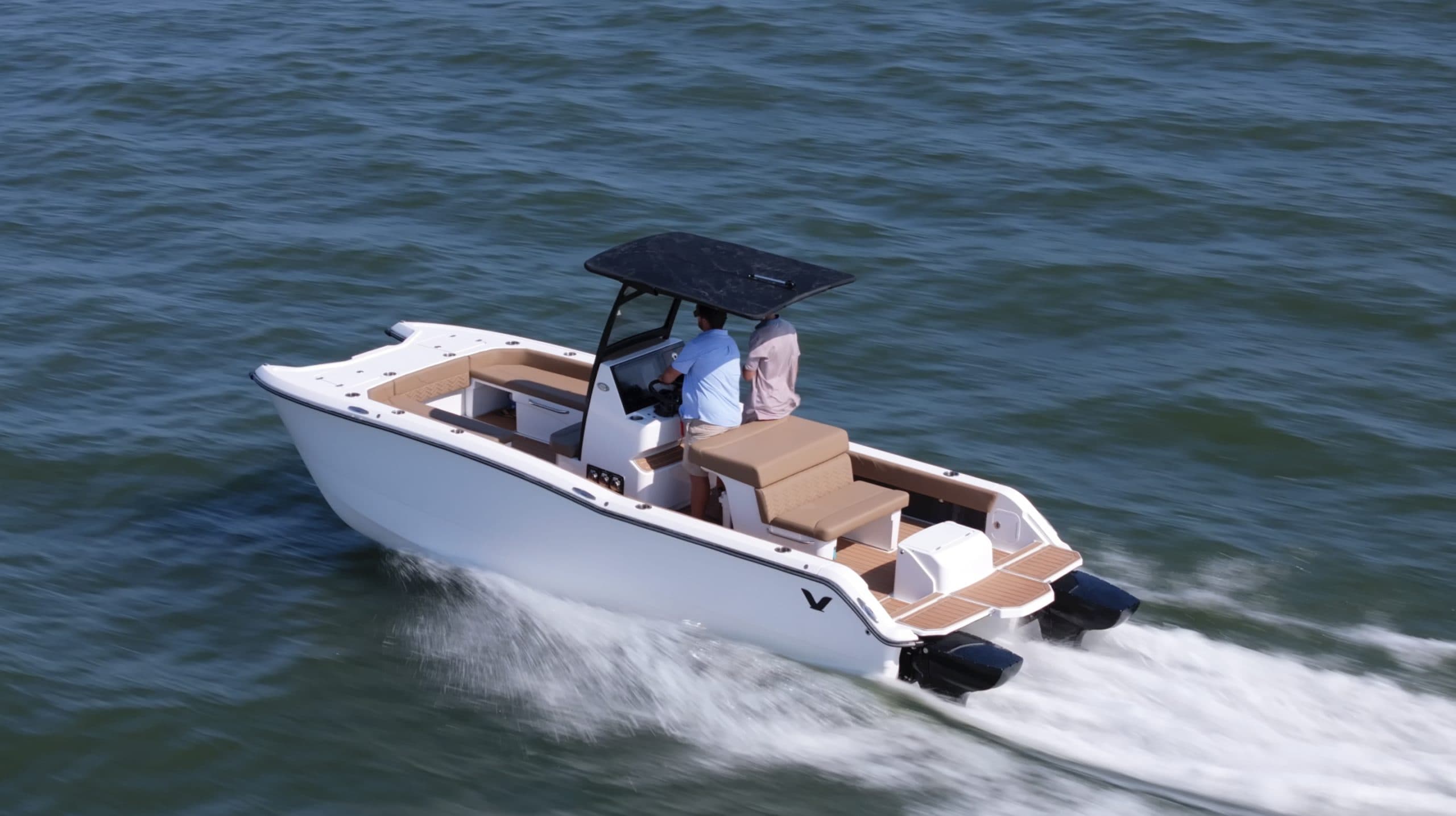 White catamaran Artemis 23 - cruising on open water, with a canopy, tan seating, swim platform, and twin outboard motors.