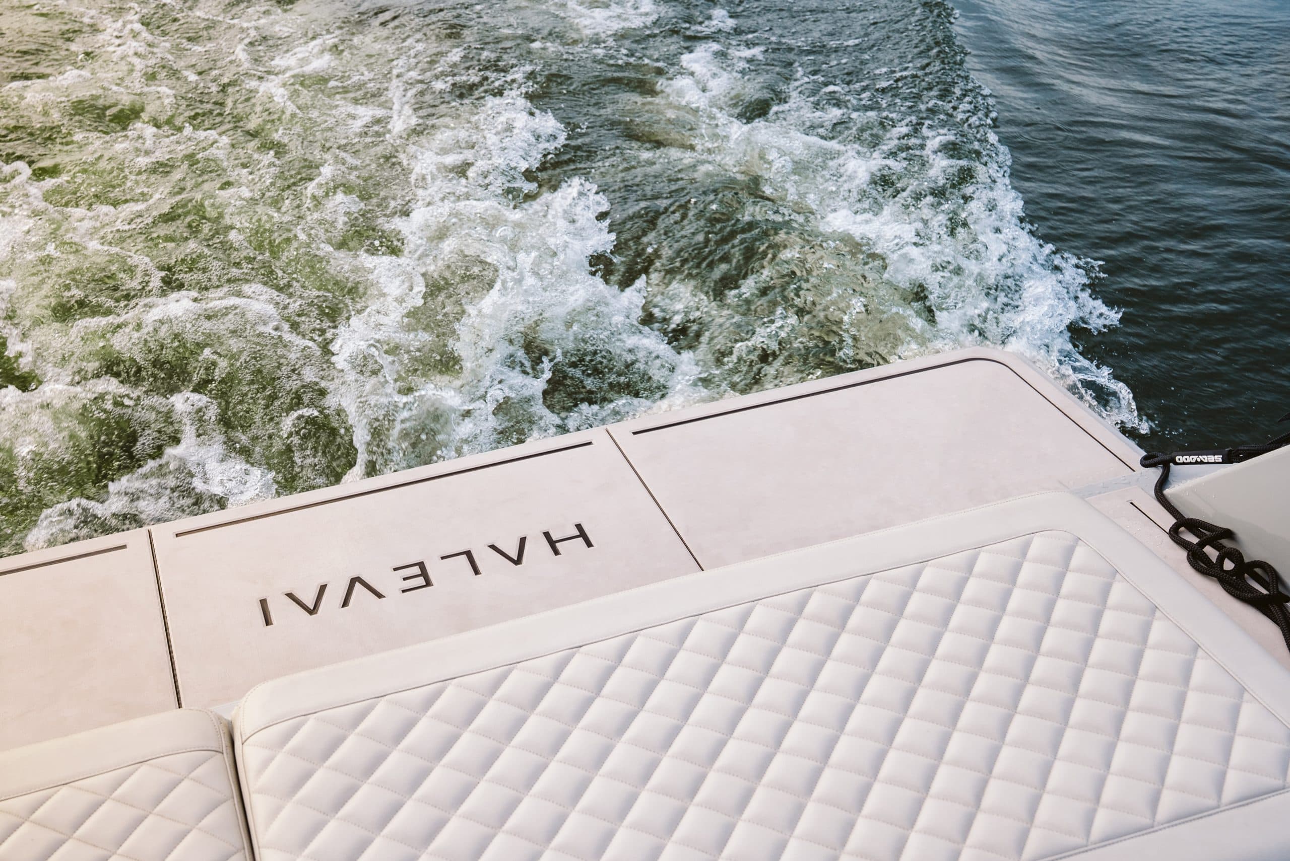 Aft deck of the Halevai model2050 with quilted upholstery and wake visible behind the boat