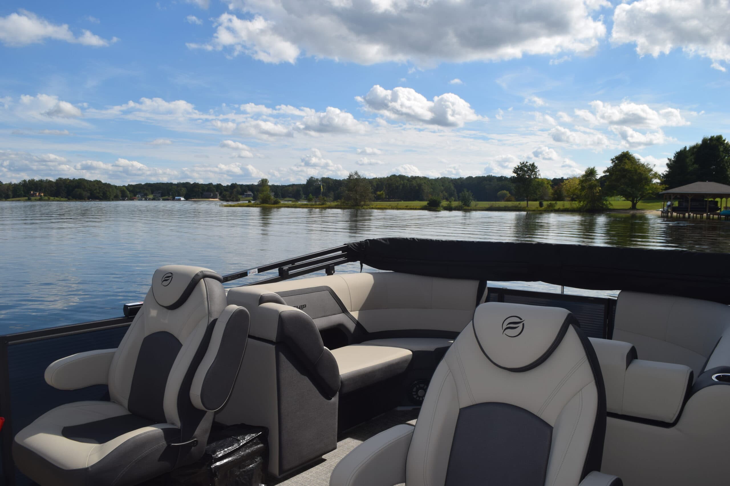 Flagship Discover cockpit seen from the stern, showing upholstered seating and the lake beyond