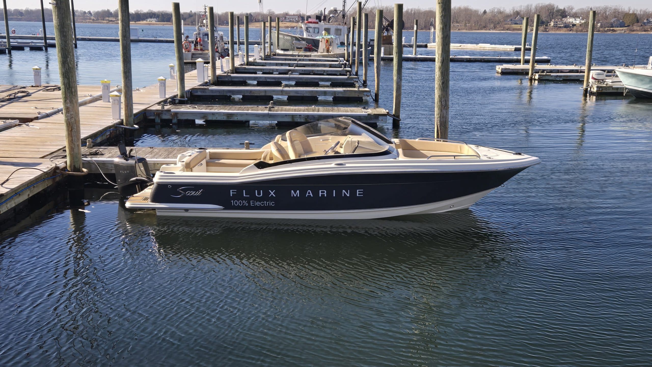 Scout 215 Dorado motorboat with cream seating docked in a marina, viewed from the side.
