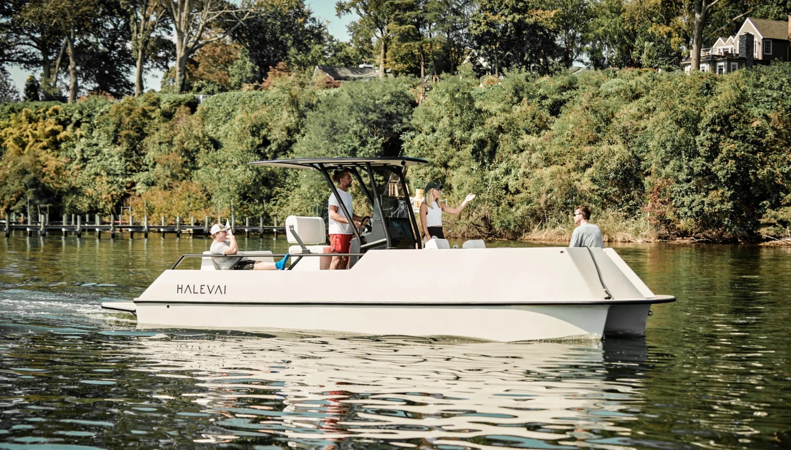 Halevai model2050 boat cruising on calm water, with several passengers aboard and tree-lined shore in the background.