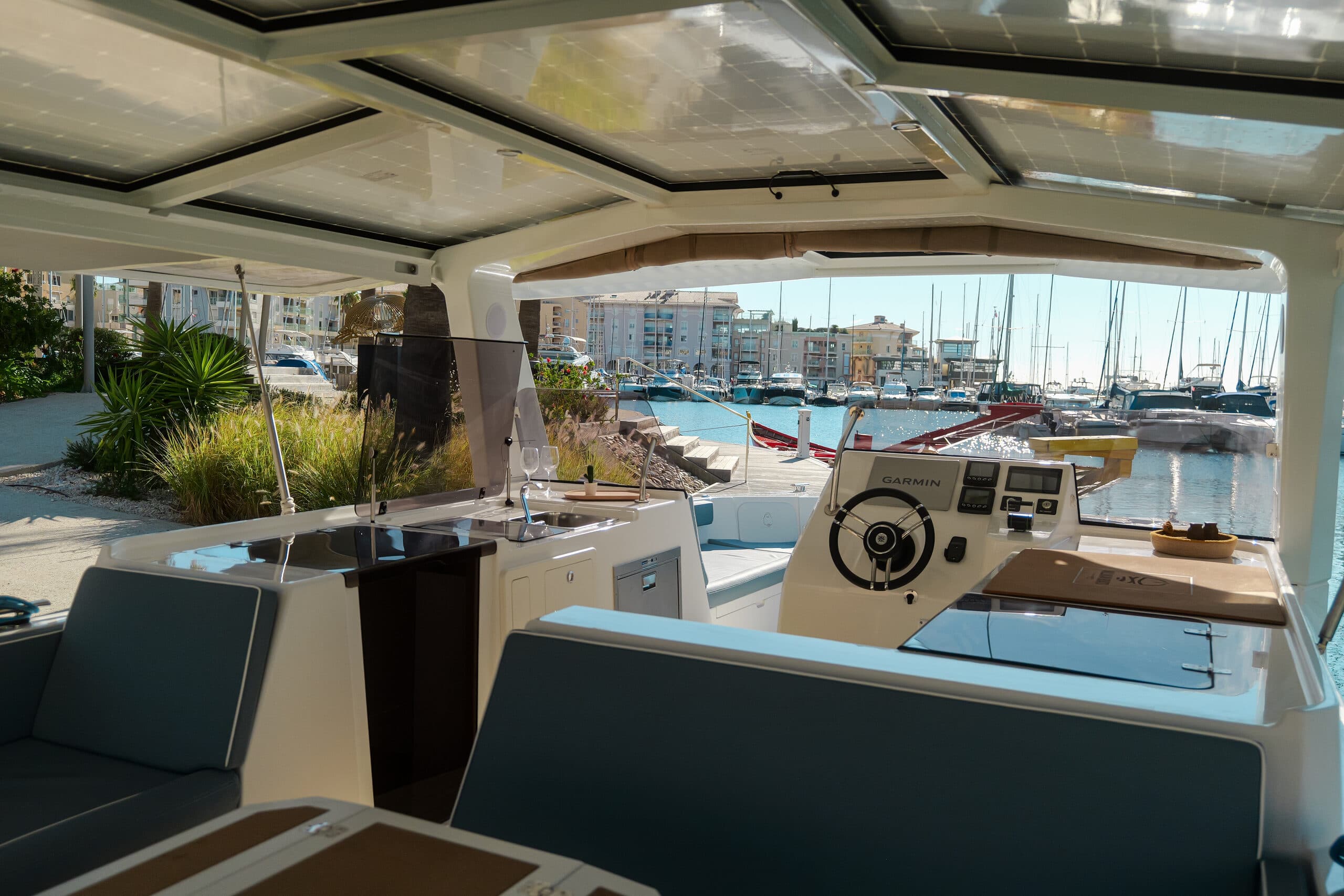 Millikan M10 helm and cockpit viewed from the aft seating area, with the marina visible through the windshield.