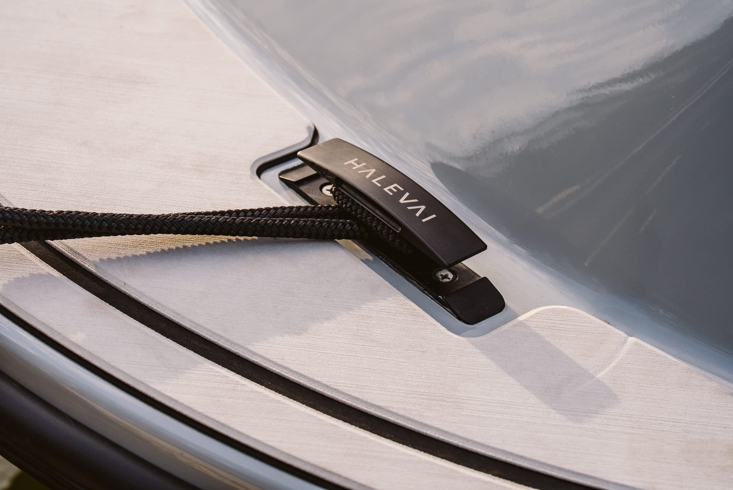 Close-up of the black Halevai-branded cleat on the light-colored deck of a boat.
