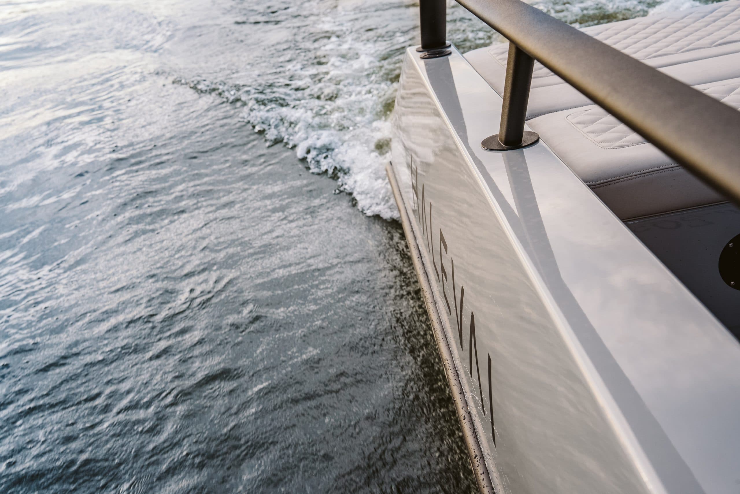 Halevai model2050 side deck and railing viewed from above, with the boat moving through water.
