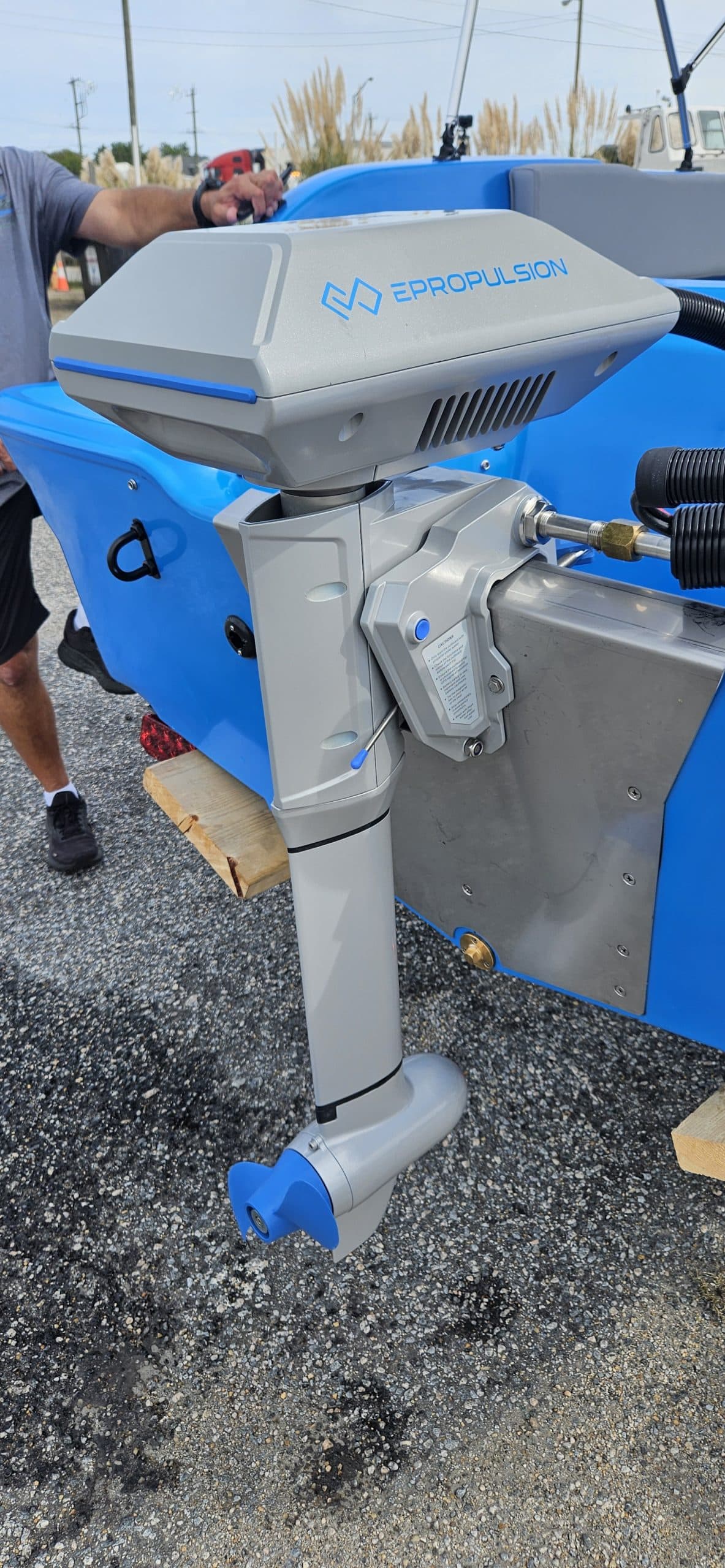 Vision Marine Phantom electric outboard motor mounted on a boat, with blue cowling, lower unit, propeller, and steering hardware visible.