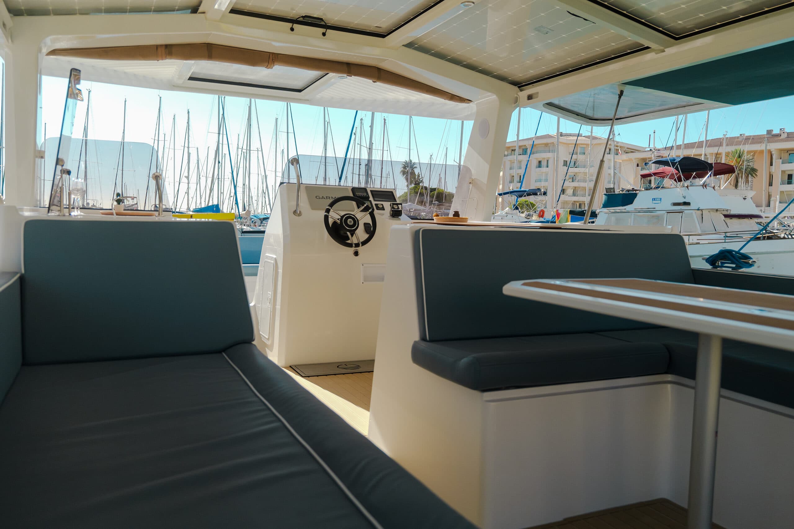 Millikan M10 saloon seating and helm viewed from inside the cabin, with marina visible through the windows