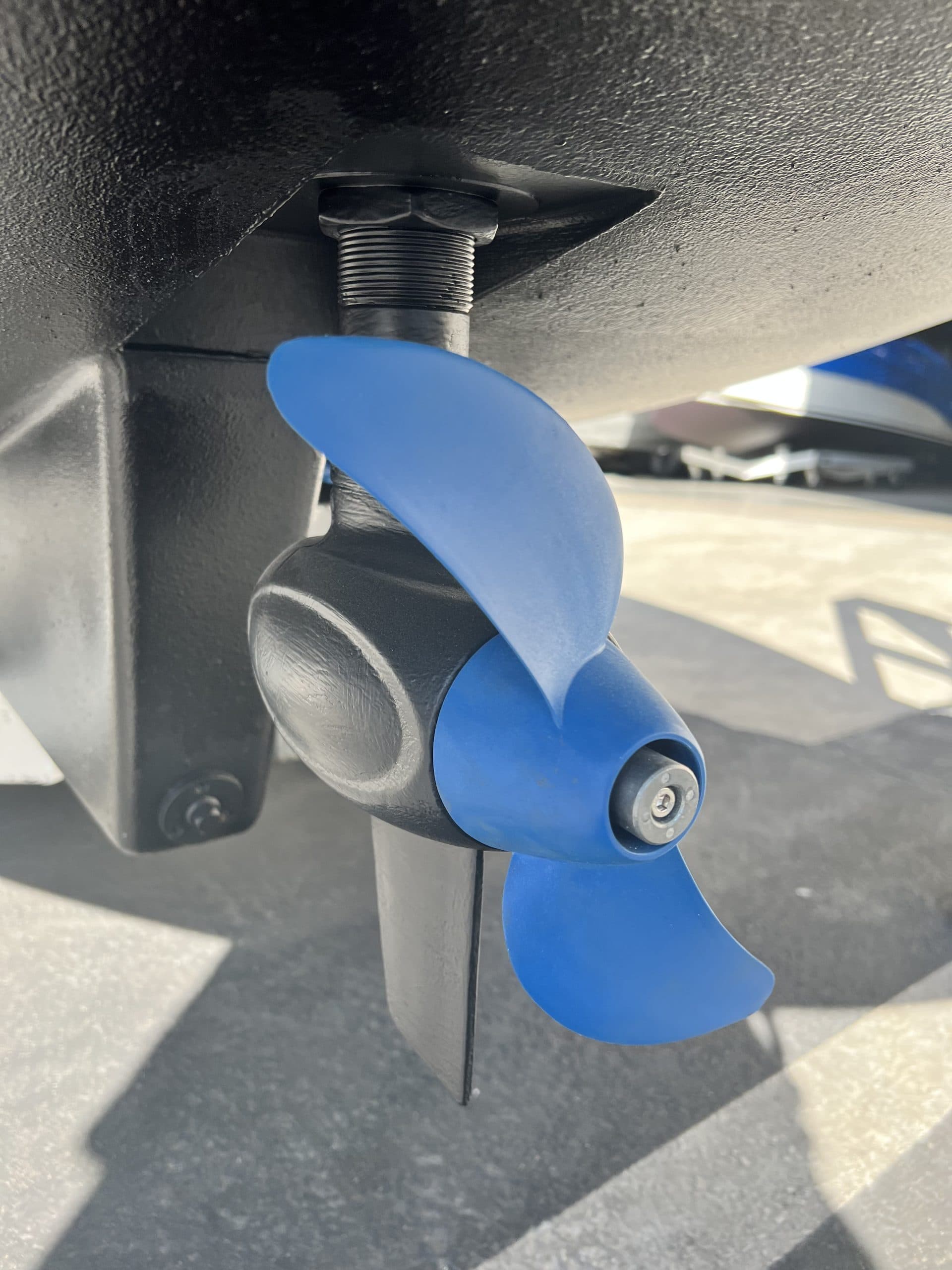 Blue electric outboard propeller and lower unit mounted beneath a 2024 Vision Marine Fantail 217 boat hull.