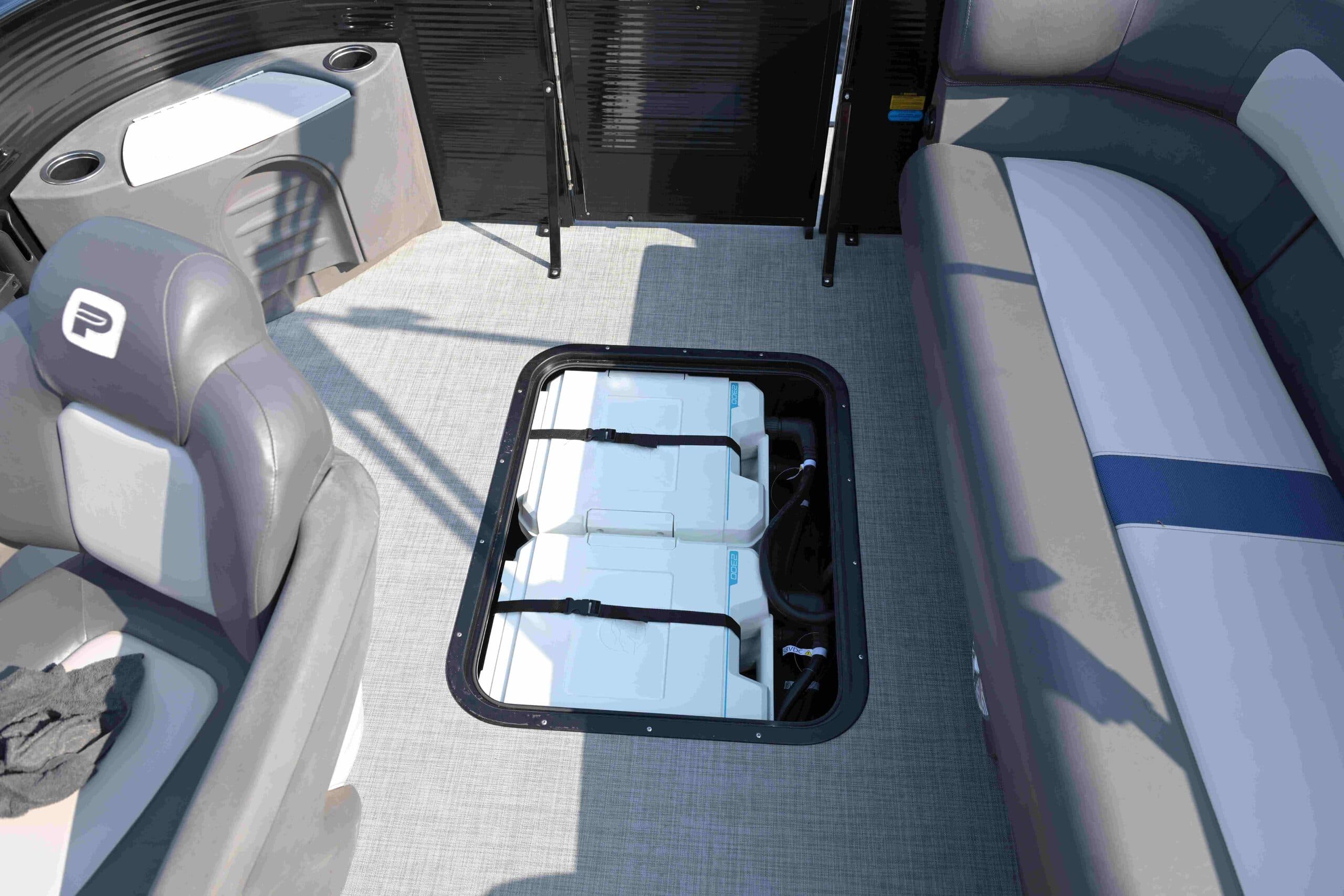 Interior view of a Princecraft Brio E17 showing cushioned seating, carpeted flooring, and an open center storage compartment.