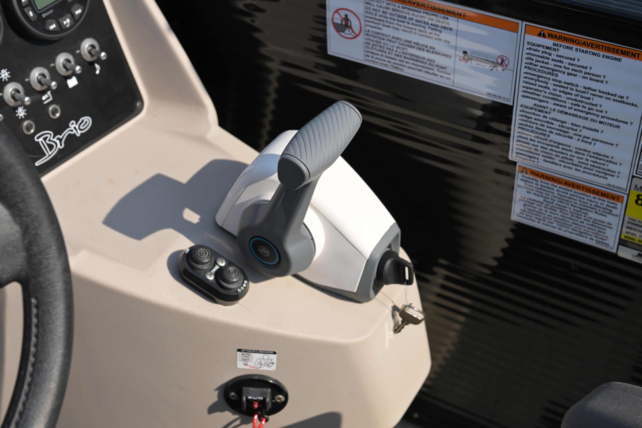 Princecraft Brio e 17 boat console with steering wheel, throttle control, ignition, gauges, and safety labels.