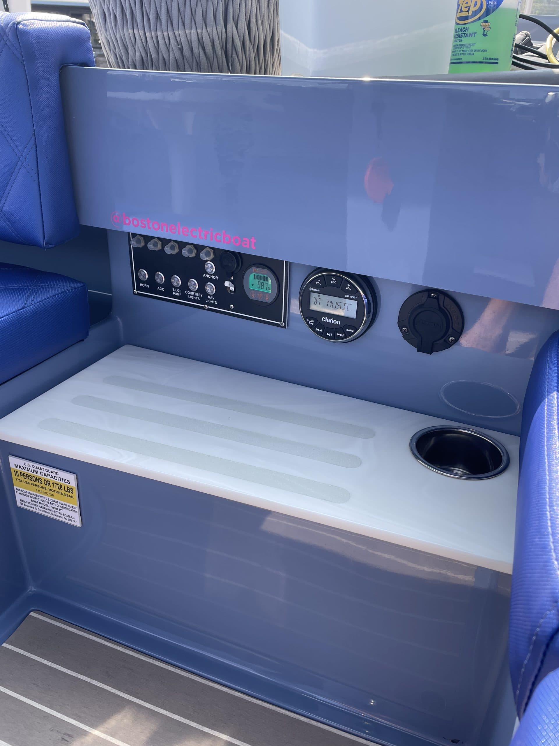 Vision Marine Fantail 217 Electric boat cockpit console with battery monitoring controls, round gauge, cup holder, and cushioned seating.