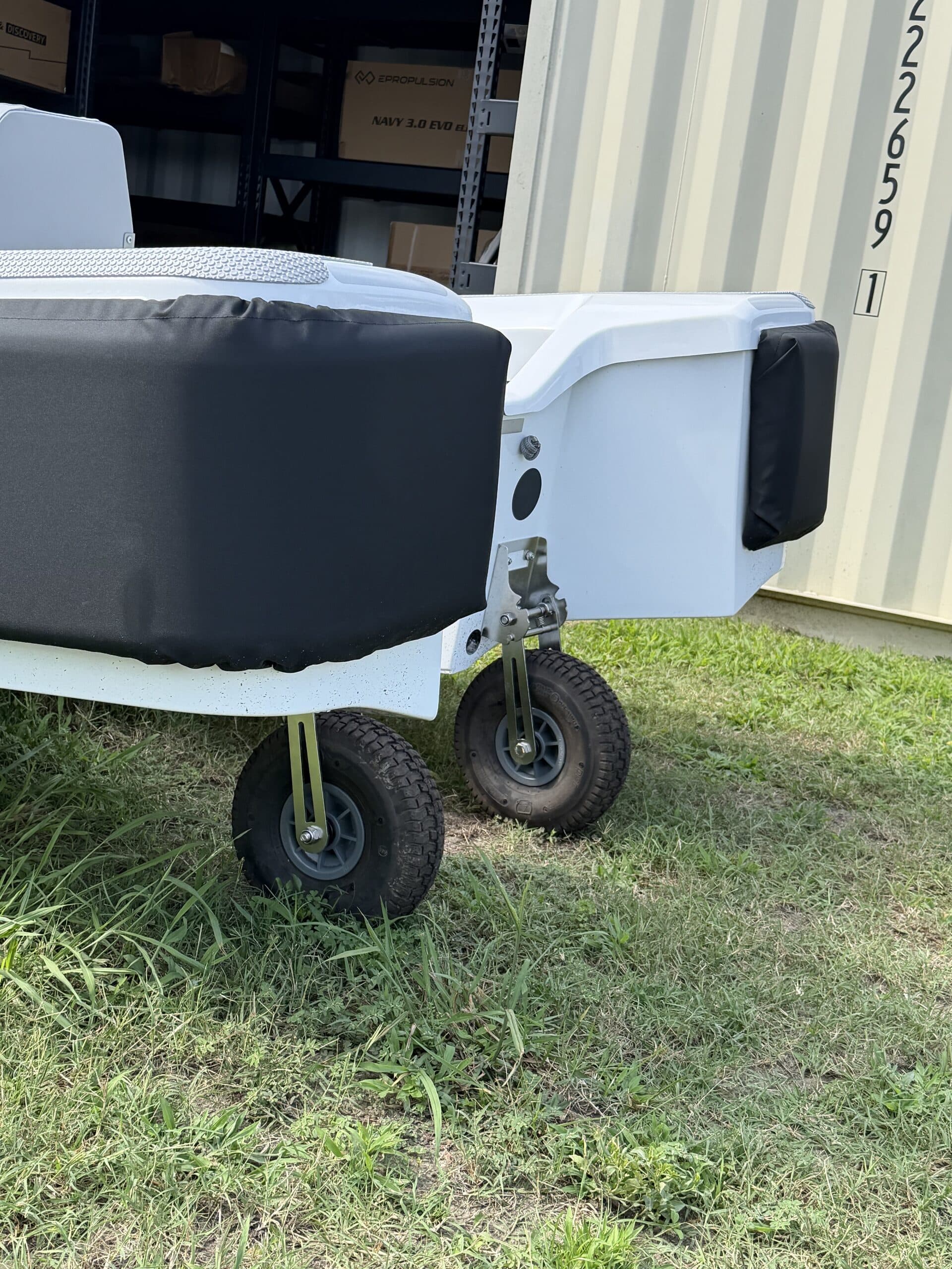 Close-up side view of a 2026 Offshore Cruising Tenders OC300 stern showing padded seating, transom hardware, and two small support wheels.