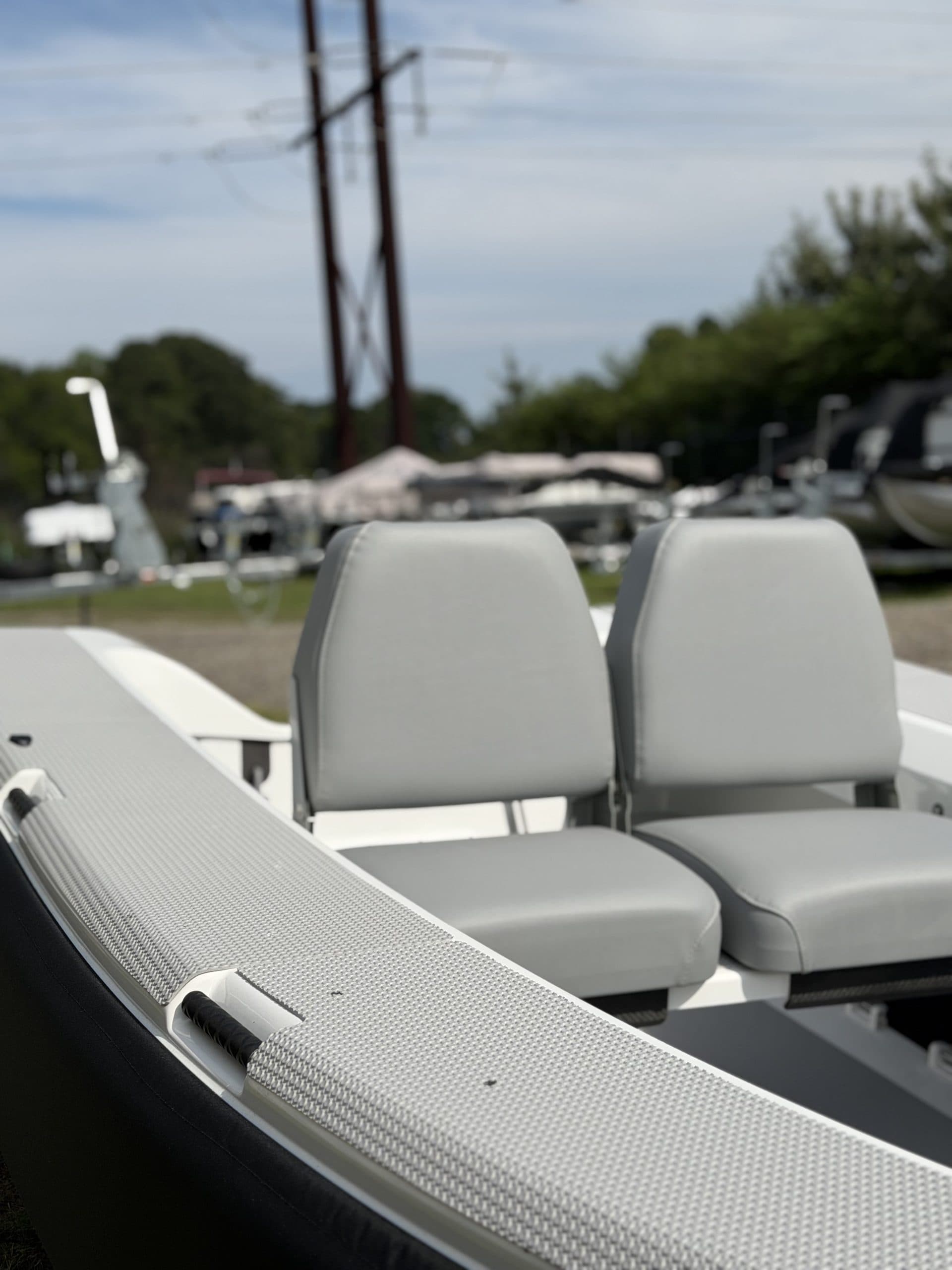 Close view from the side of a 2026 Offshore Cruising Tenders OC300 showing two gray seats and the textured gunwale.