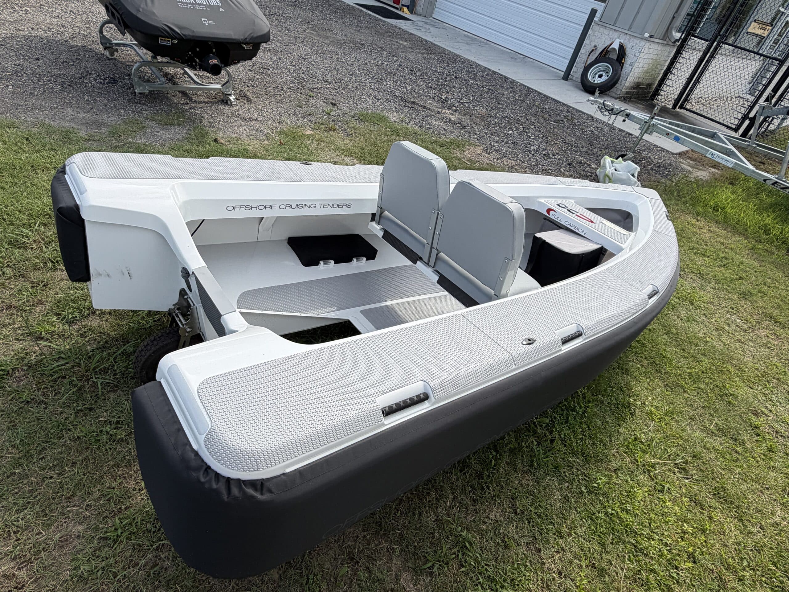 View from above the stern quarter into the open cockpit of a compact inflatable tender (2026 Offshore Cruising Tenders OC300) with two gray seats.